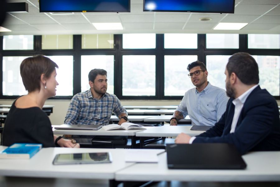 Docentes discutiendo, hablando en una mesa FGV - EAESP